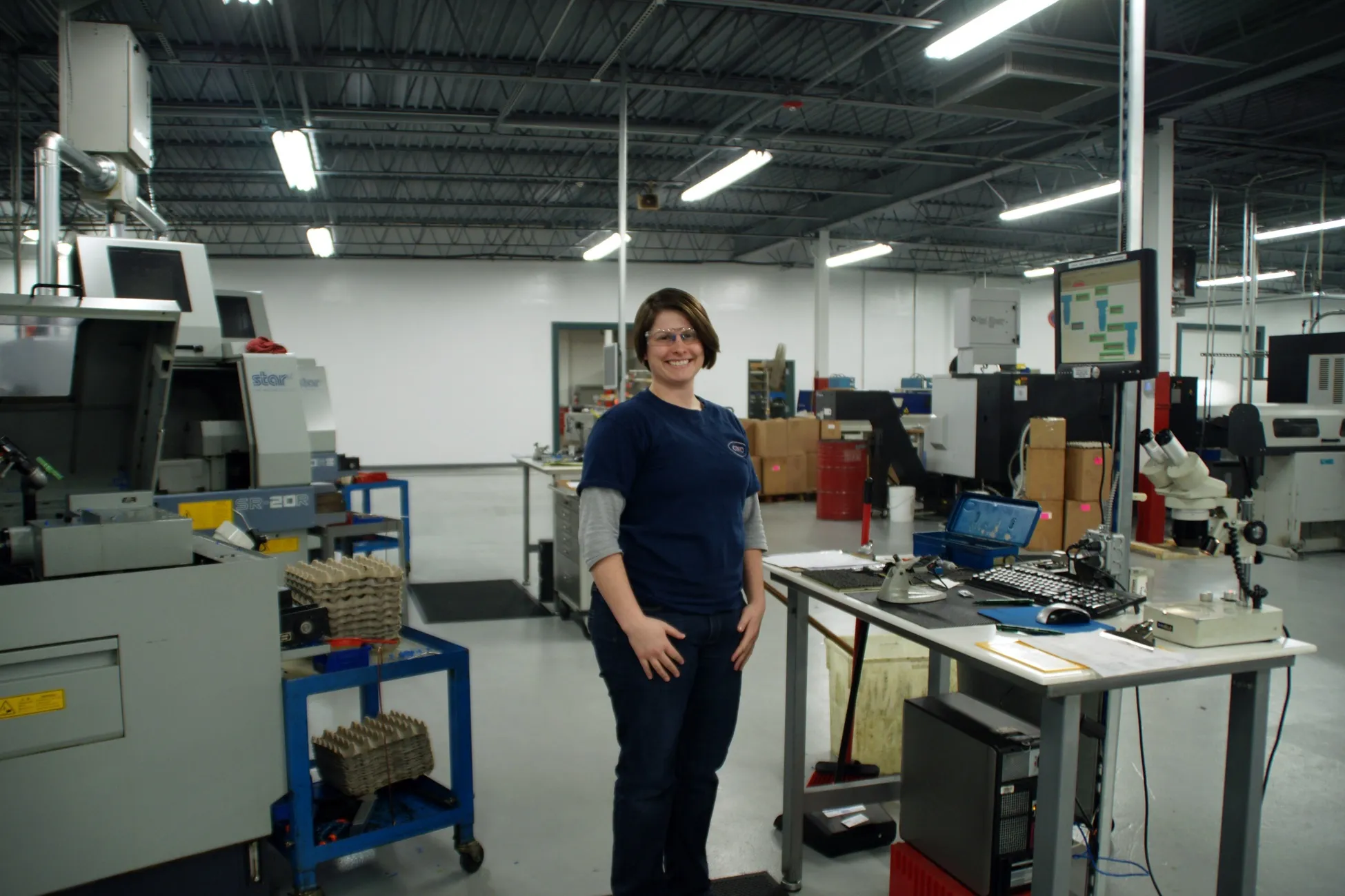 A CNC Manufacturing team member at an inspection station on the shop floor